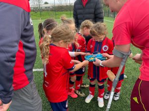 Wales international Soffia Kelly showing her Welsh cap to young players at North Cardiff Cosmos FC.