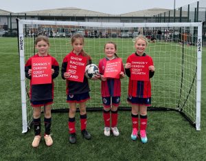 North Cardiff Cosmos Under 8 Girls team holding red cards to support the Show Racism the Red Card campaign.
